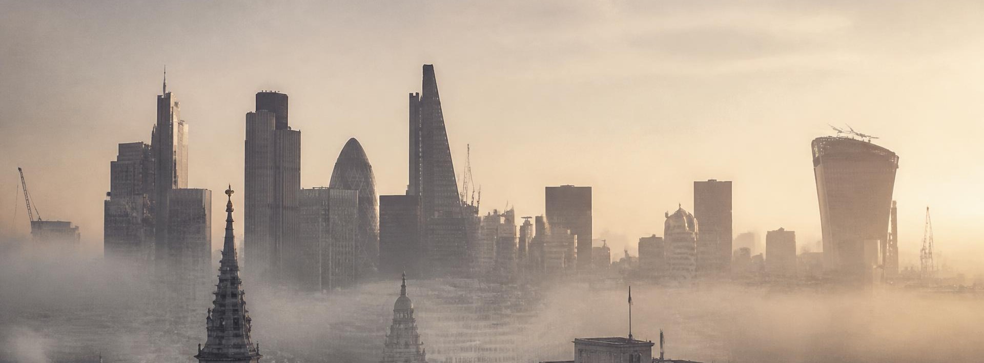 The City of London skyline at dawn, viewed through low mist